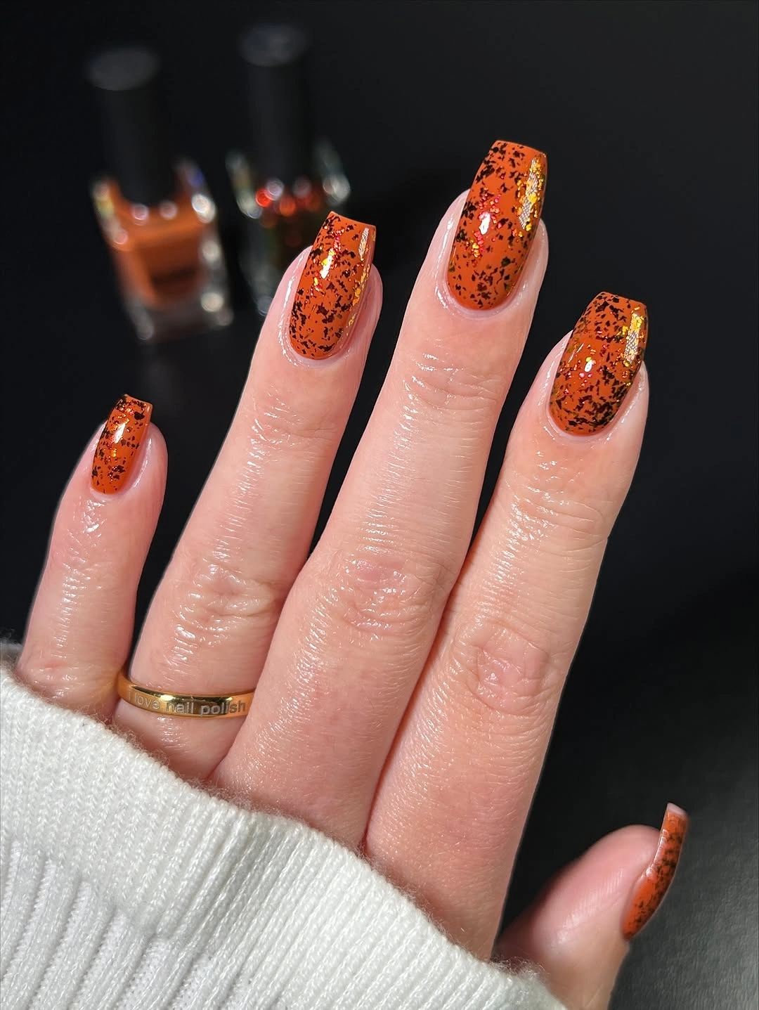 Burnt orange square nails with black speckles and gold flecks