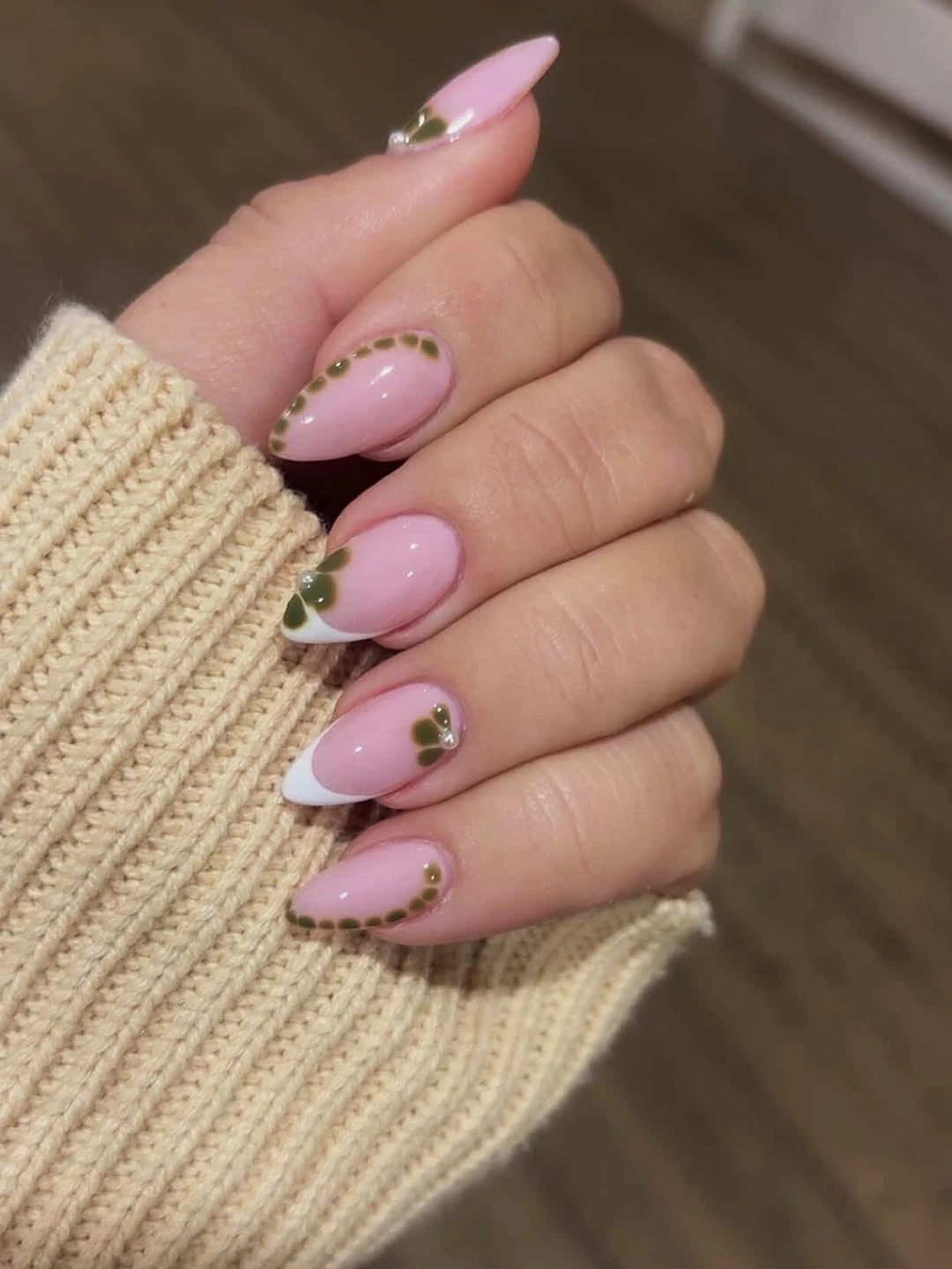 Pale pink almond nails with olive dot borders