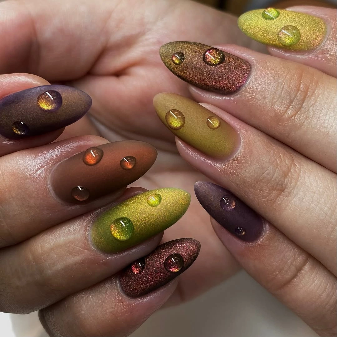 Earth tone almond nails with glossy droplet accents