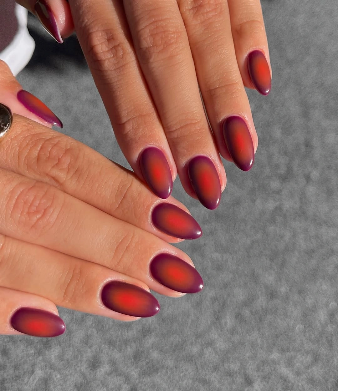 Long almond nails with a glossy red plum and berry gradient