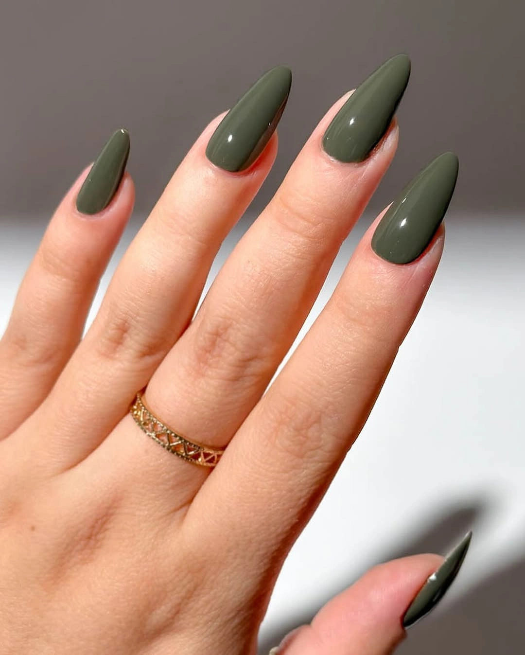 Long almond nails with muted olive green and warm neutral accents