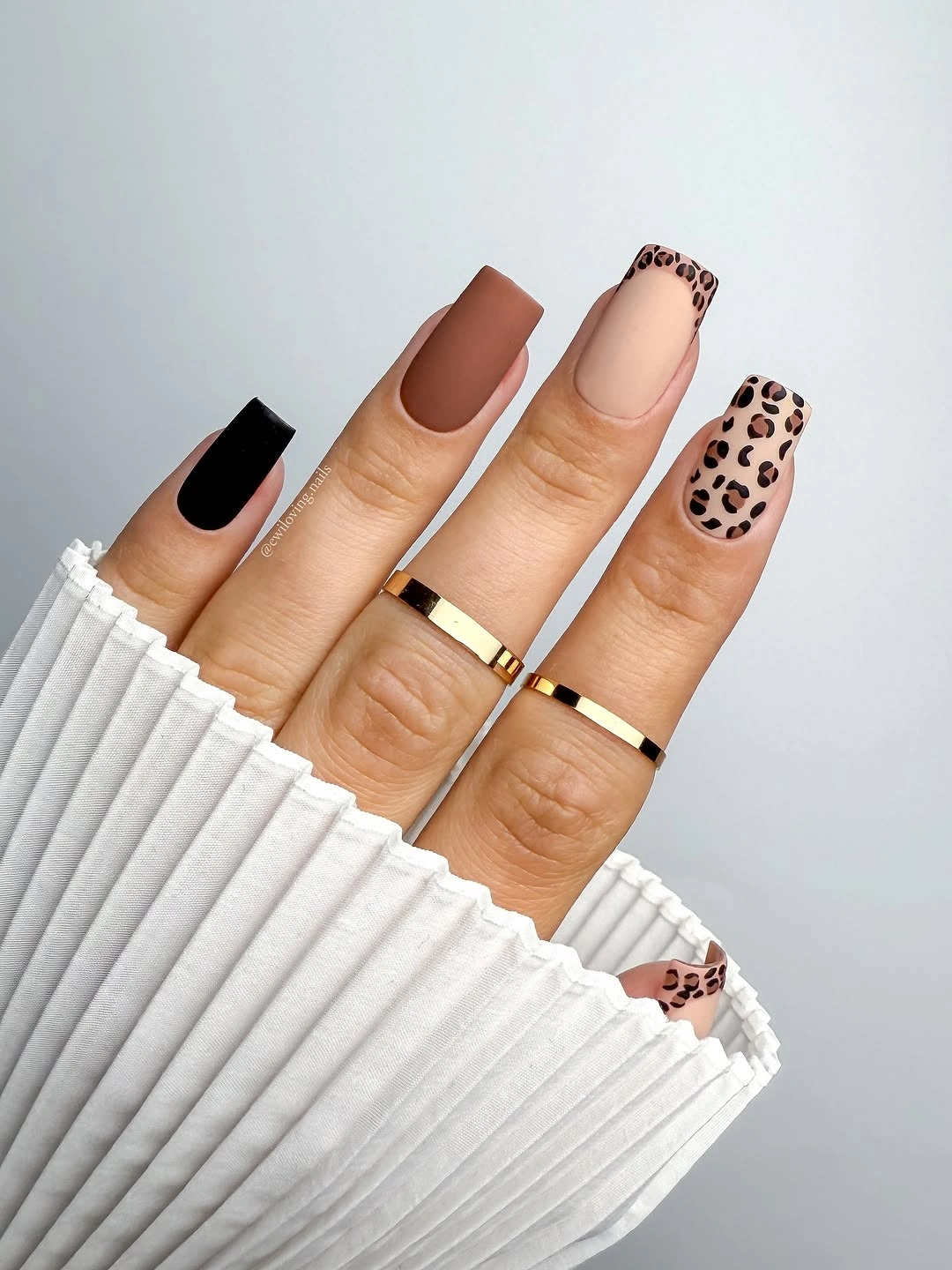 Short square neutral nails with one small leopard print accent