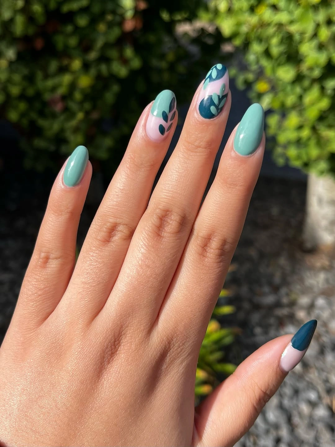 Turquoise almond nails with pale blue and white botanical accents