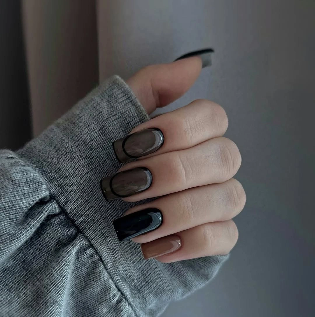 Short square nails mixing pale neutrals black outlines and dark accents