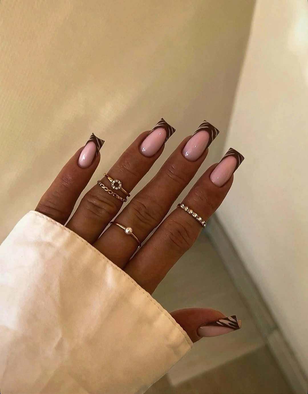 Medium square pale pink nails with dark brown curved borders
