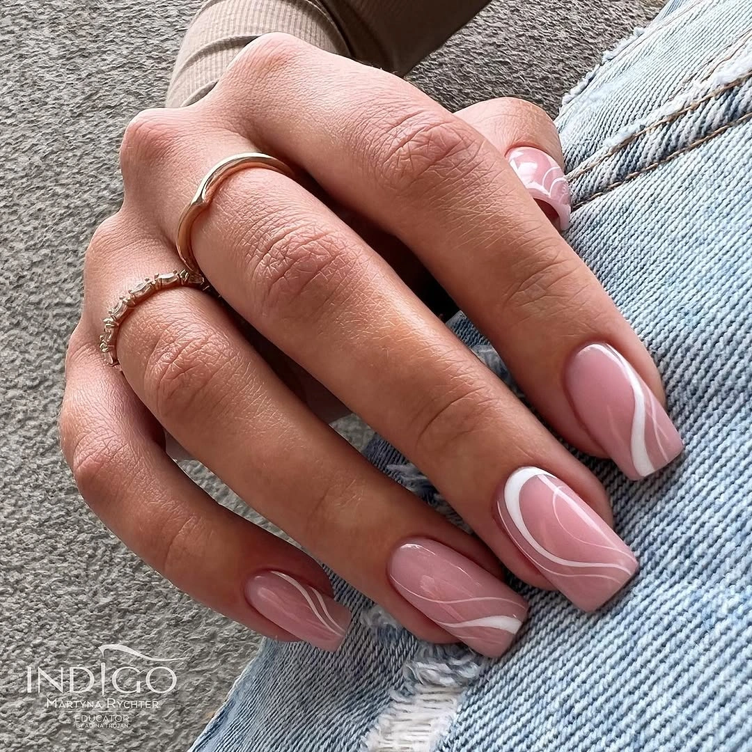 Medium square dusty pink nails with a single white curved accent
