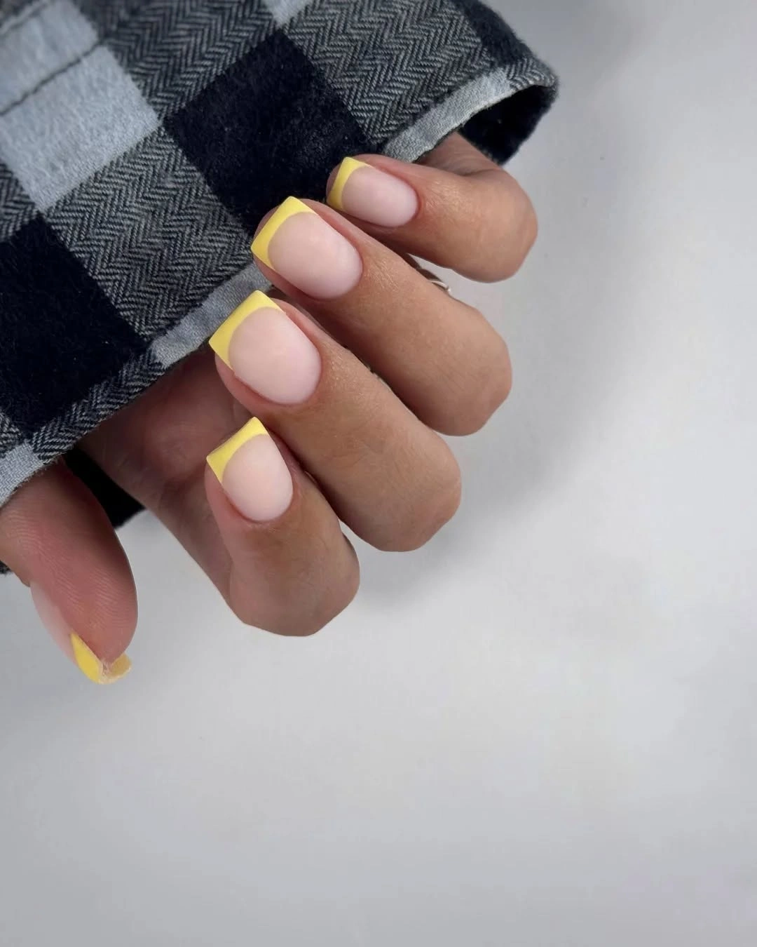 Short square pale pink nails with narrow yellow tips