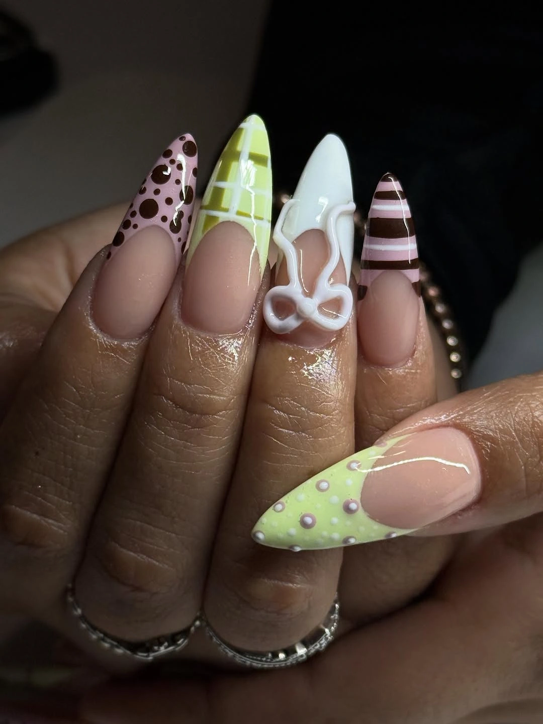 Mauve almond nails with spots plaid lines and bright lime accents