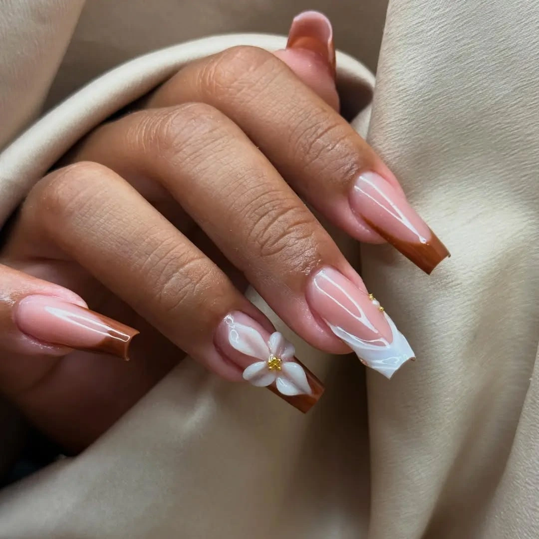 Long almond pink nails with white accents brown lines and yellow flower