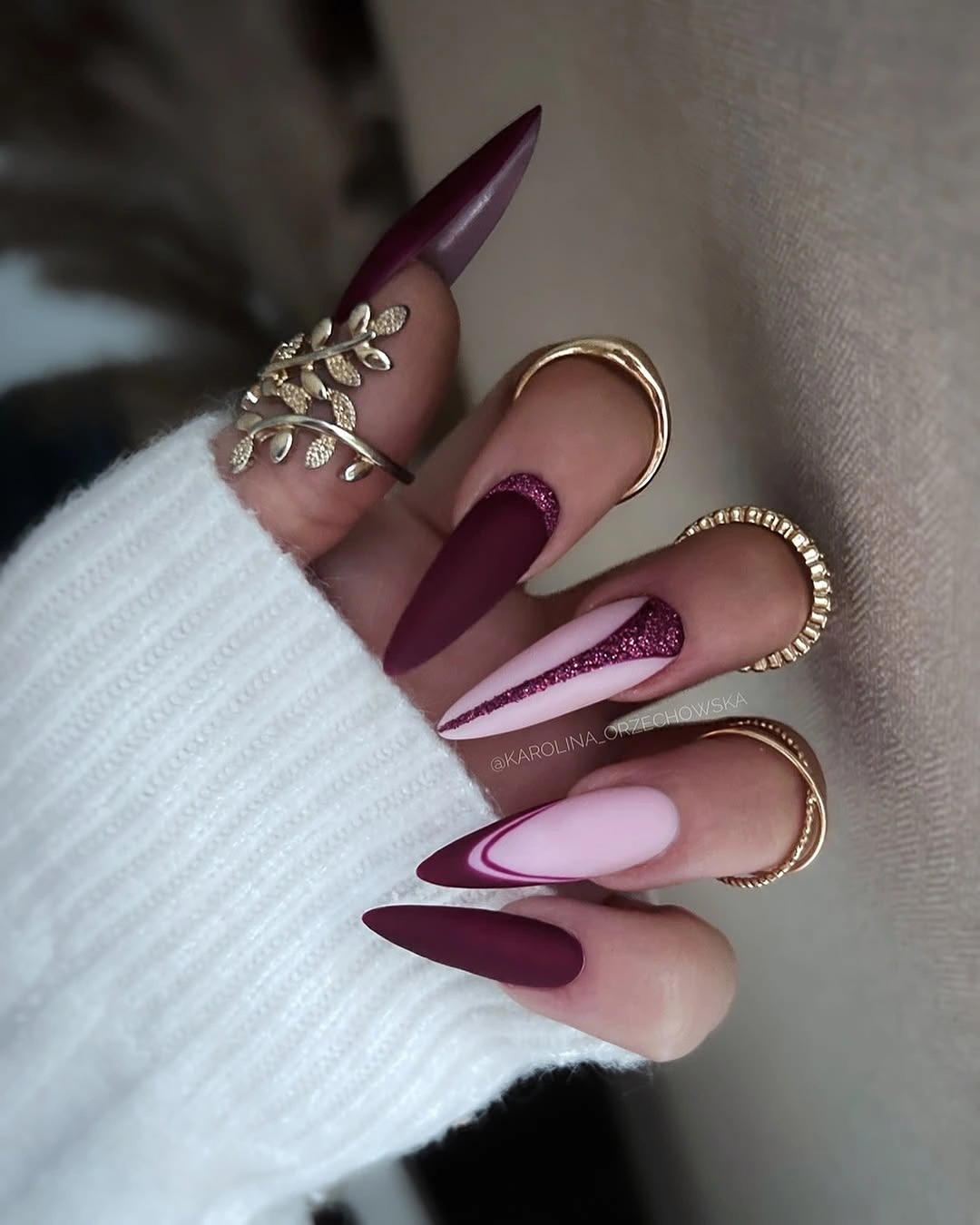 Very long plum and pale pink stiletto nails with ornate accents