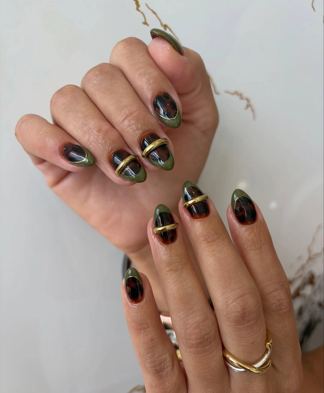 Medium almond nails in black olive and green with thin gold bands