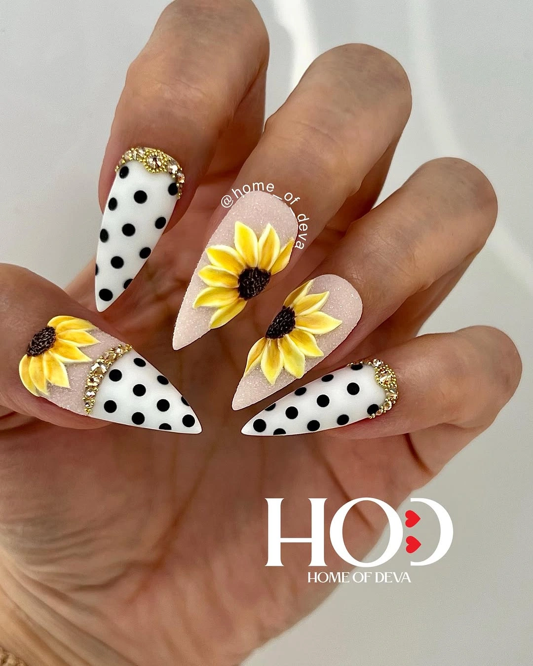 Long almond white nails with black dots and yellow sunflower accents