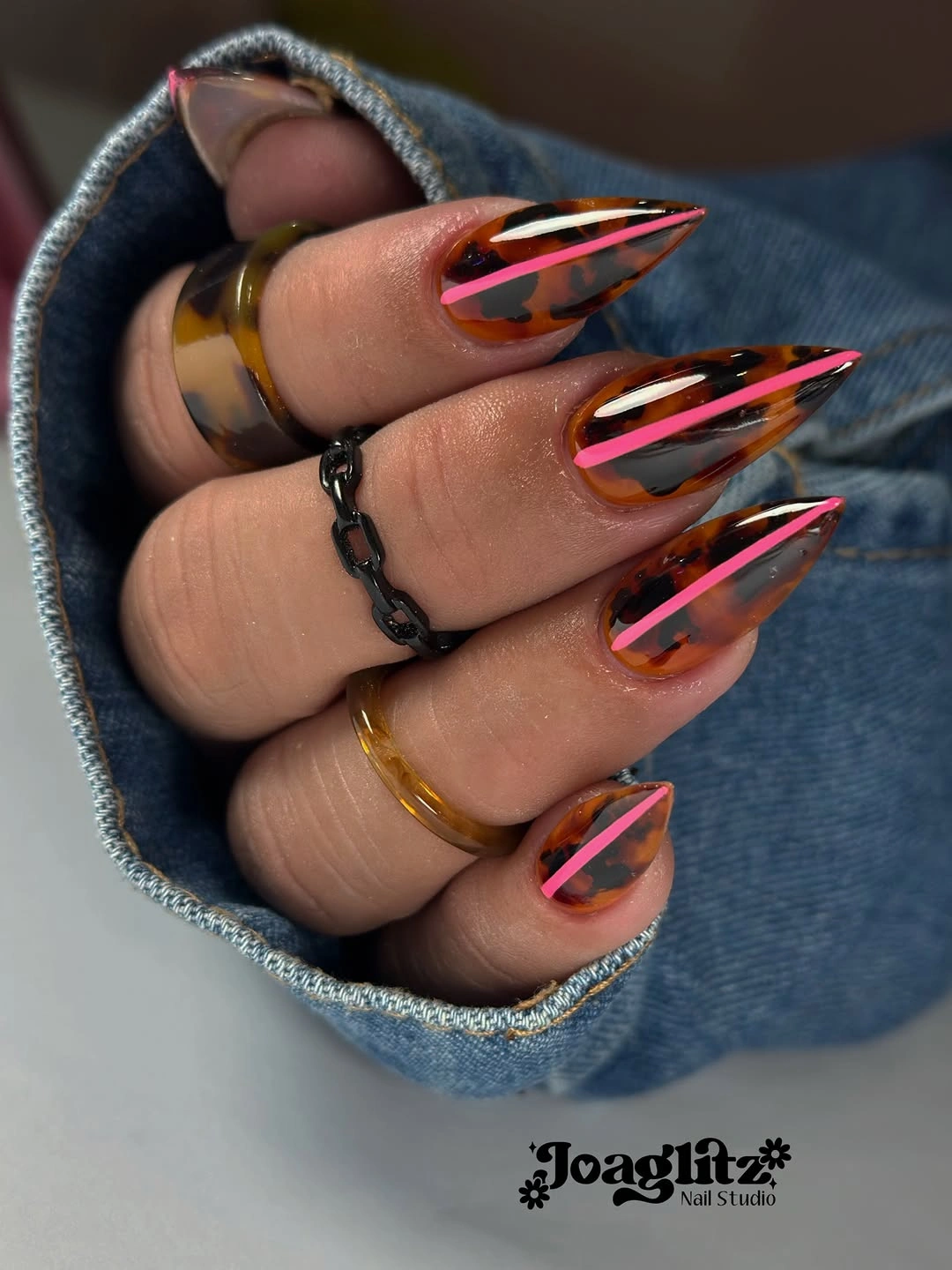 Very long stiletto nails with hot pink orange black diagonal stripes