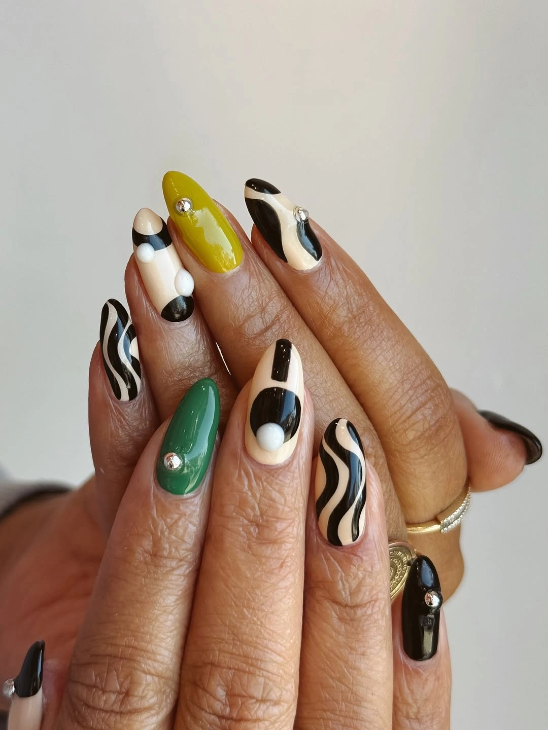 Long almond nails with green black white swirls dots and stripes
