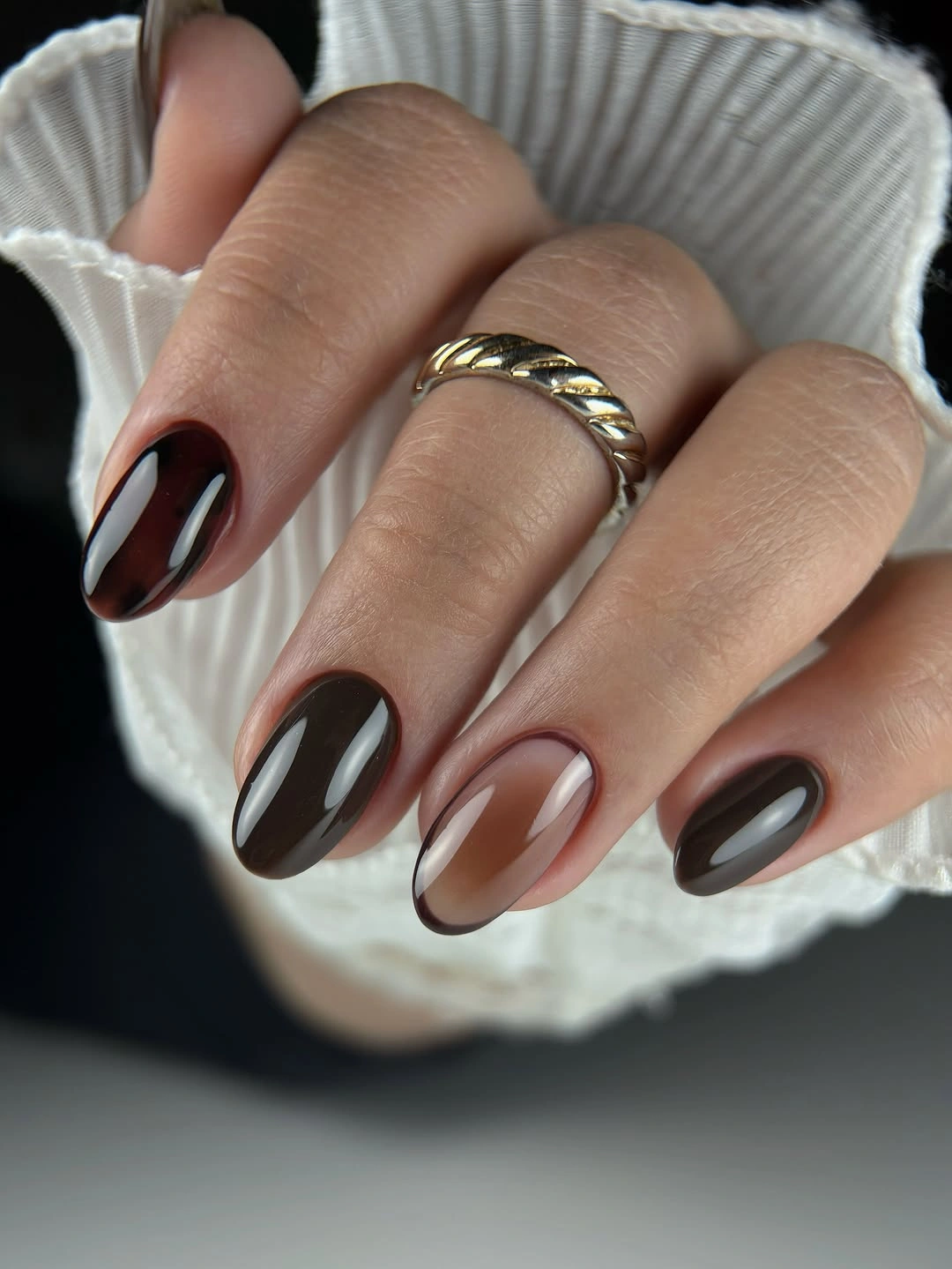 Medium almond nails in glossy espresso brown with muted neutral accents