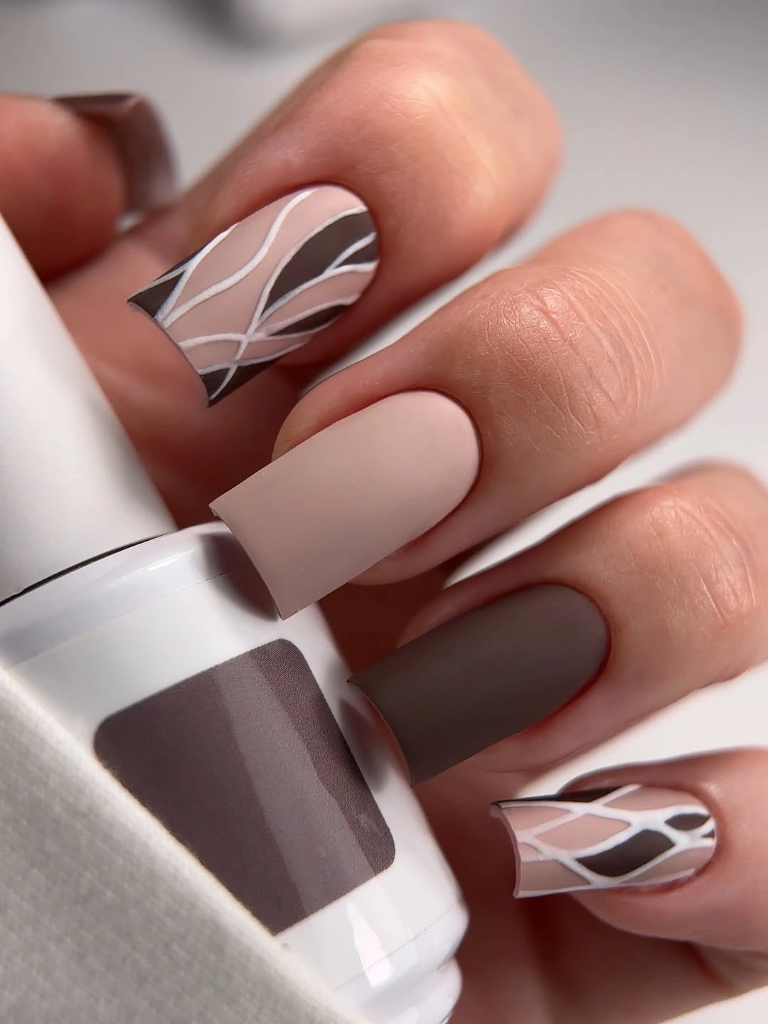 Muted nude and brown nails with abstract contour lines