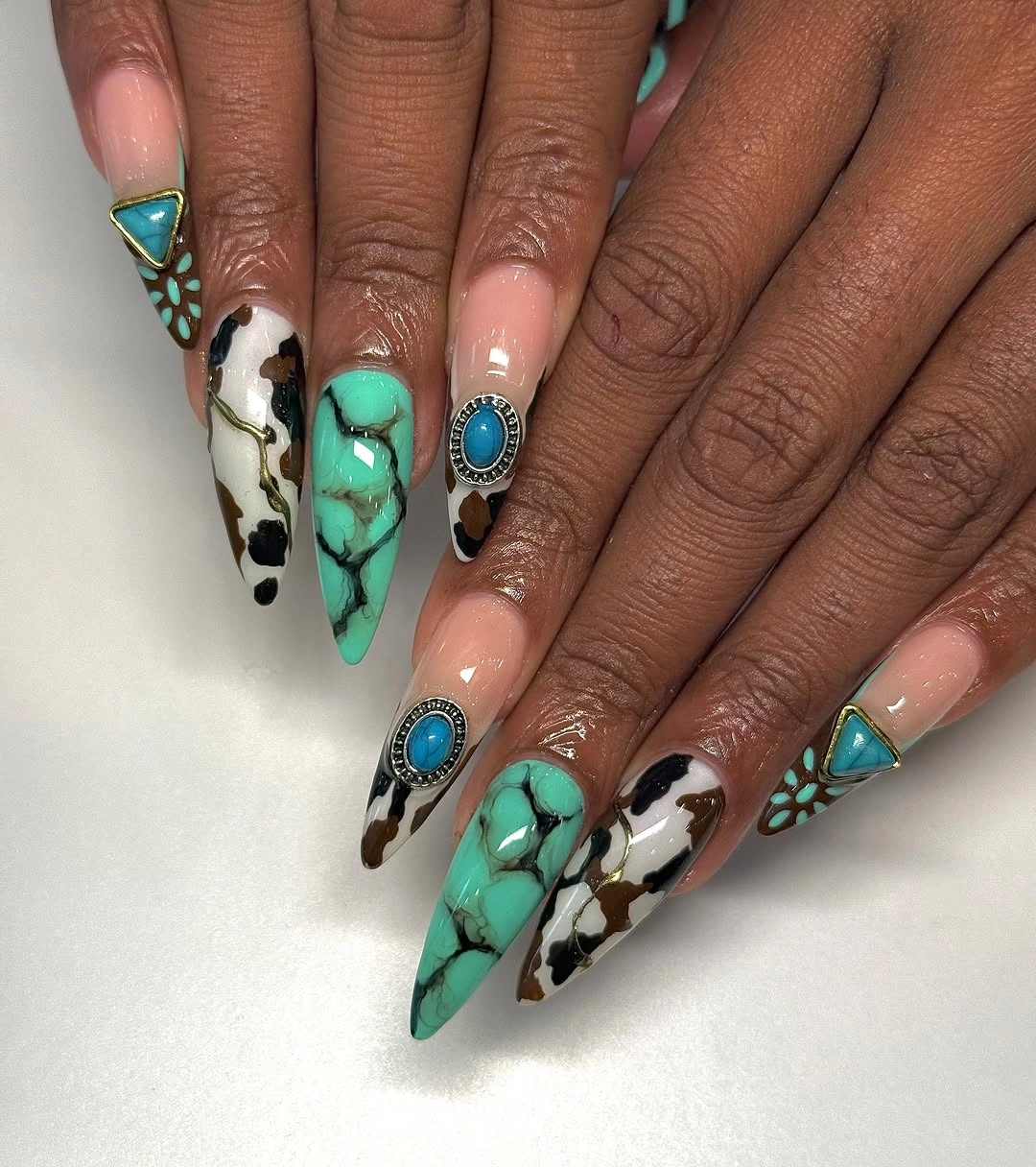 Long pointed turquoise nails with black white pattern and blue accents
