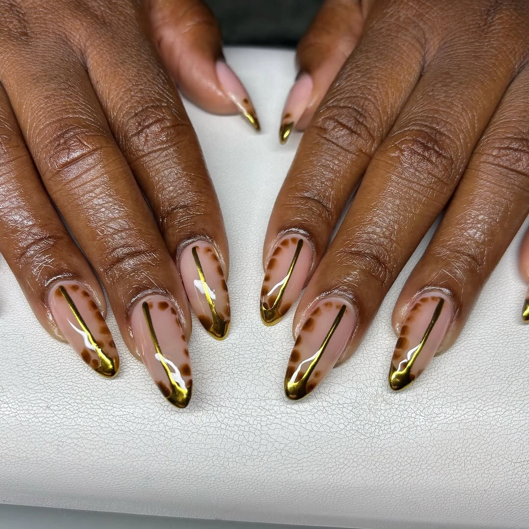 Long nude almond nails with brown and gold outlined tips