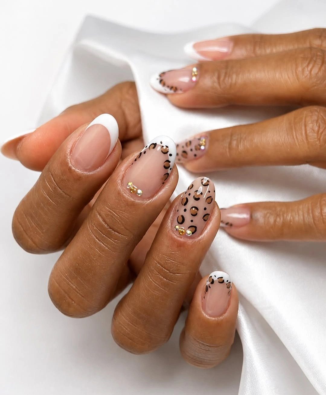 Short rounded nude nails with black tan leopard spots