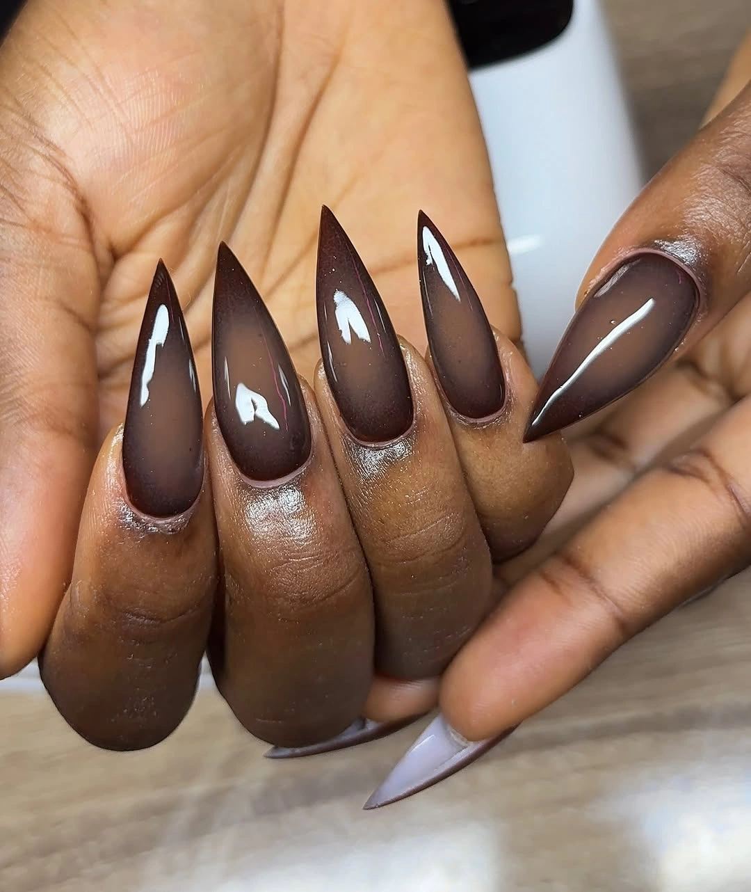 Long glossy espresso brown almond nails with reflective highlights