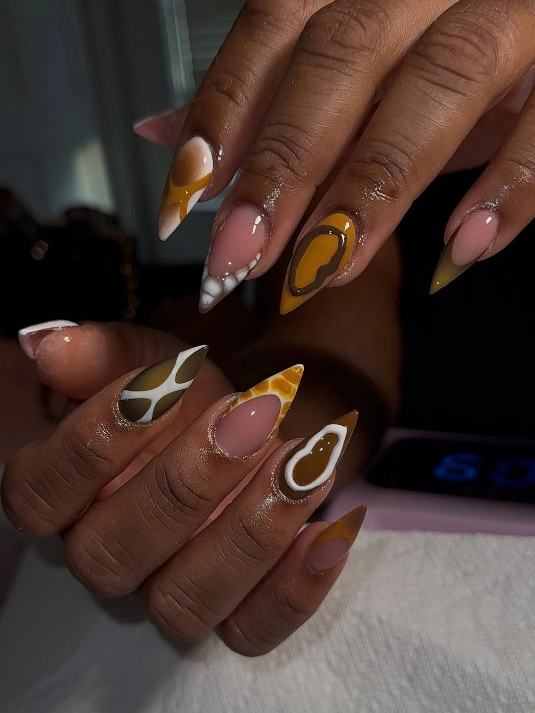 Warm abstract swirl almond nails with amber and cream contrast