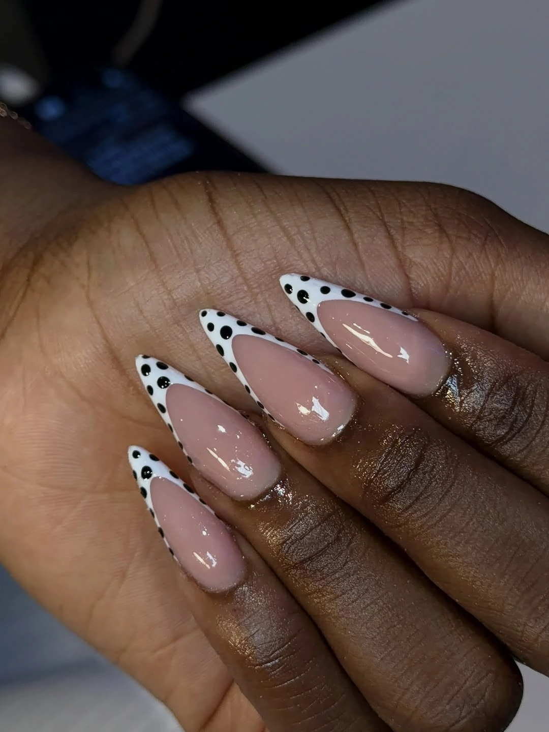 Nude almond nails with black and white spotted French borders