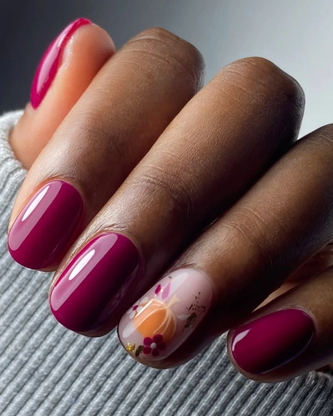 Deep berry rounded square nails with one warm floral accent