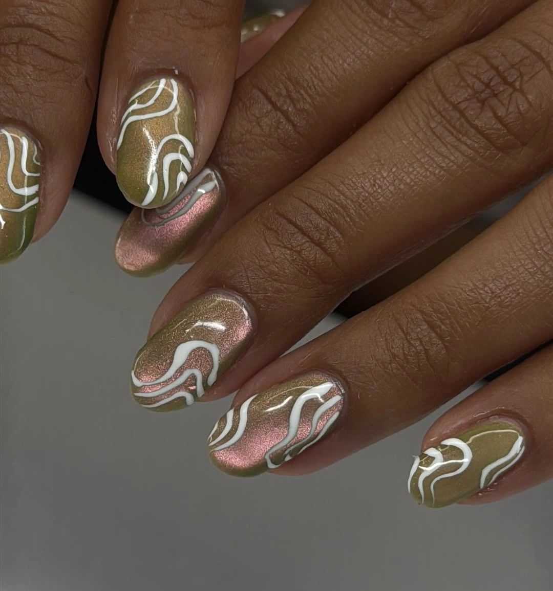 Olive short almond nails with cream waves and soft pink accents