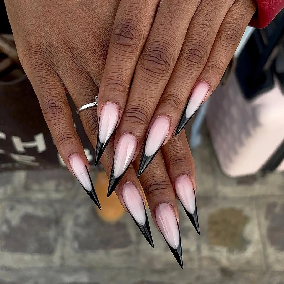 Long stiletto nails with black tips and warm blush centers