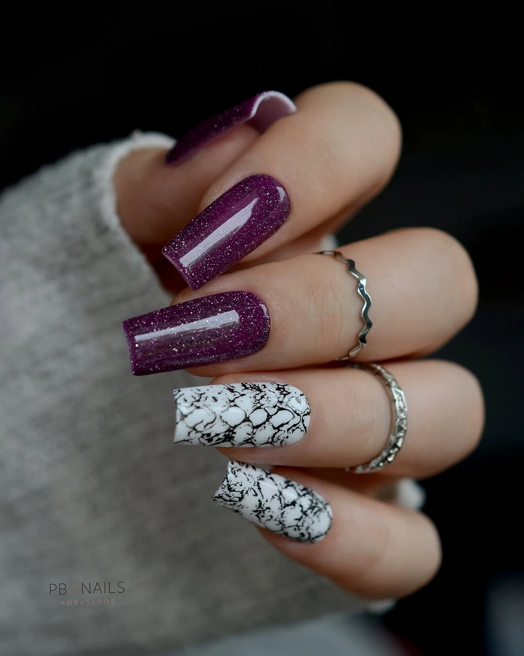 Long purple glitter nails with white marble accents