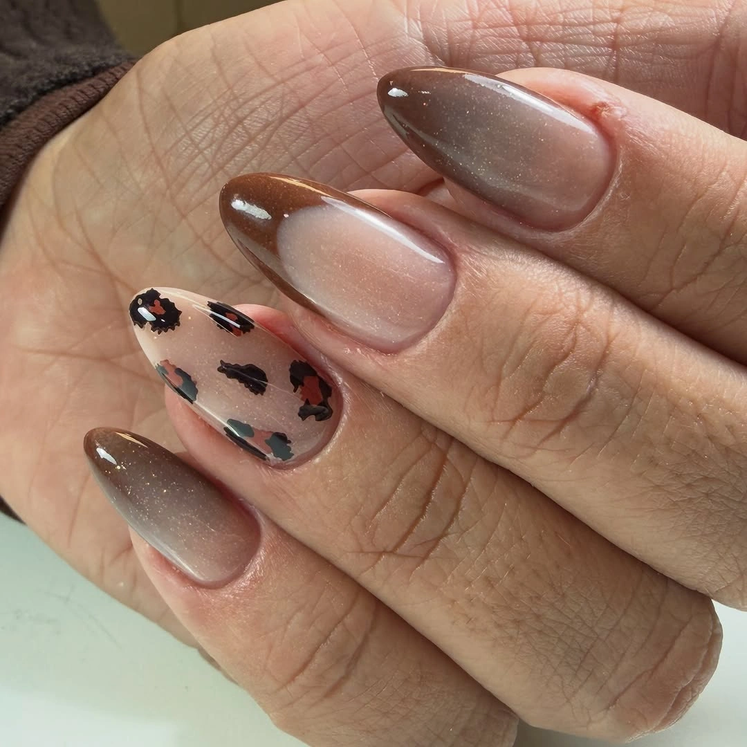 Long smoky taupe almond nails with dark abstract accents