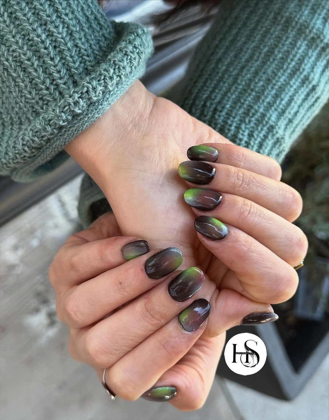 Short rounded dark green nails with shifting reflective color