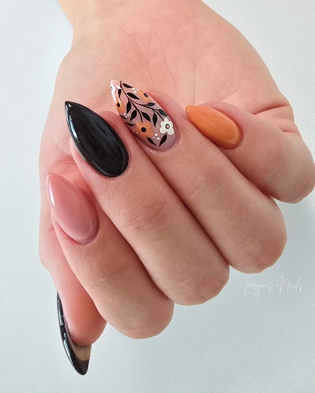 Long pointed black orange pink nails with graphic motifs