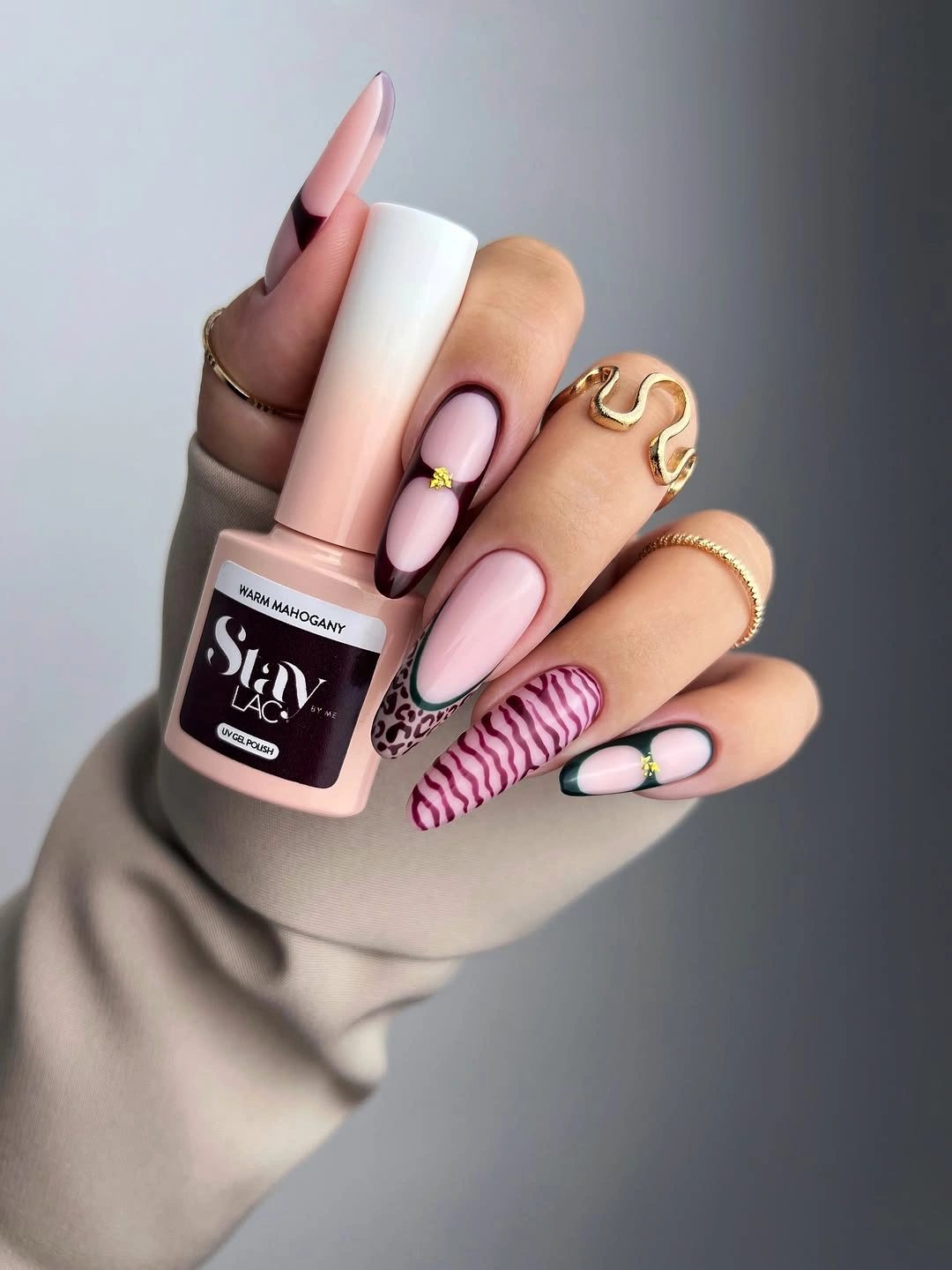 Pale pink almond nails with zebra curves and green accents