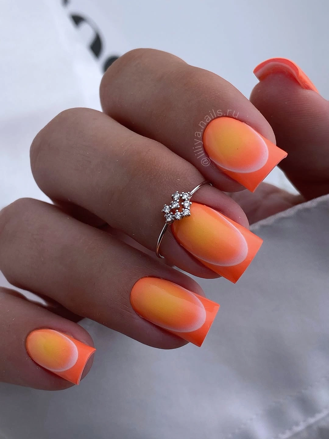 Square nails fading from nude bases into vivid coral tips