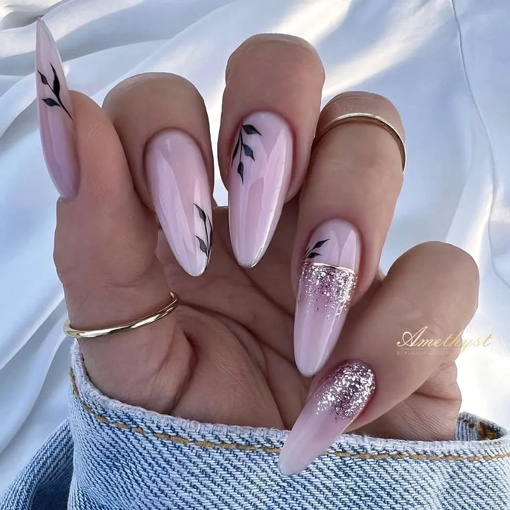 Long pale stiletto nails with black linework and silver sparkle
