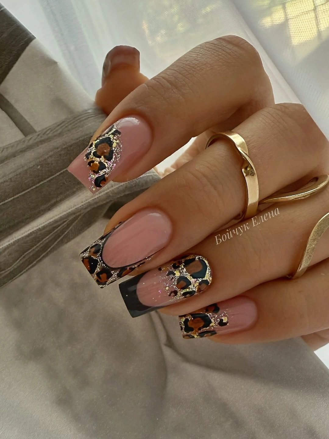 Medium blush square nails with black outlined gold-accented geometry