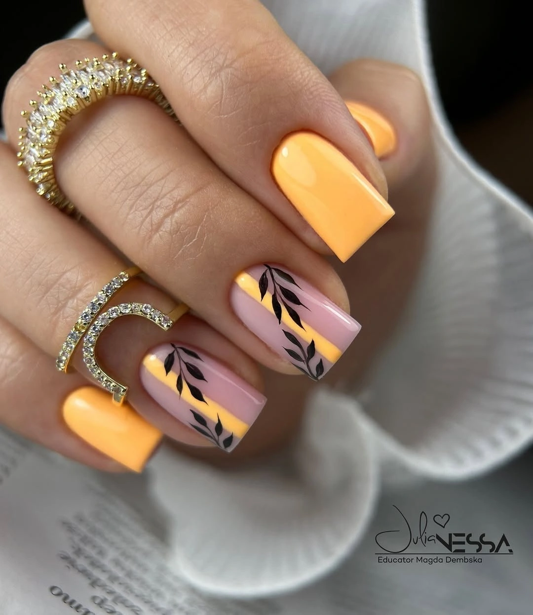 Yellow-orange square nails with lavender and black accent lines