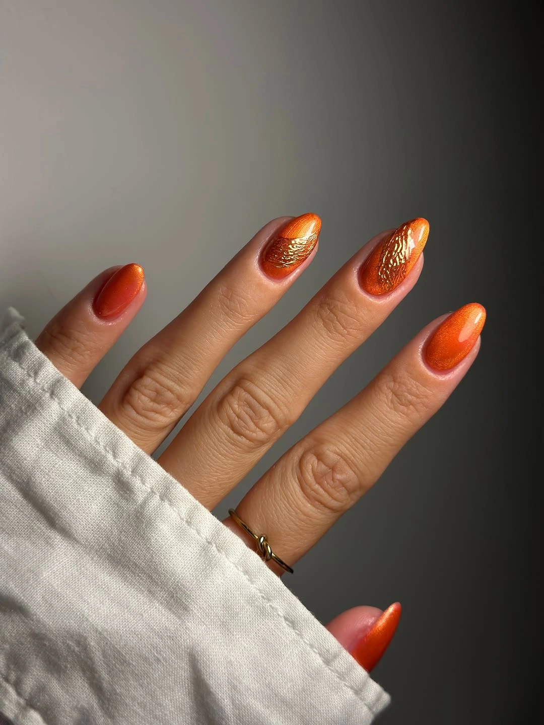 Medium almond burnt orange nails with reflective shine