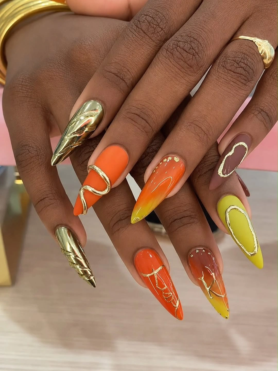 Long pointed orange lime and gold graphic fall nails