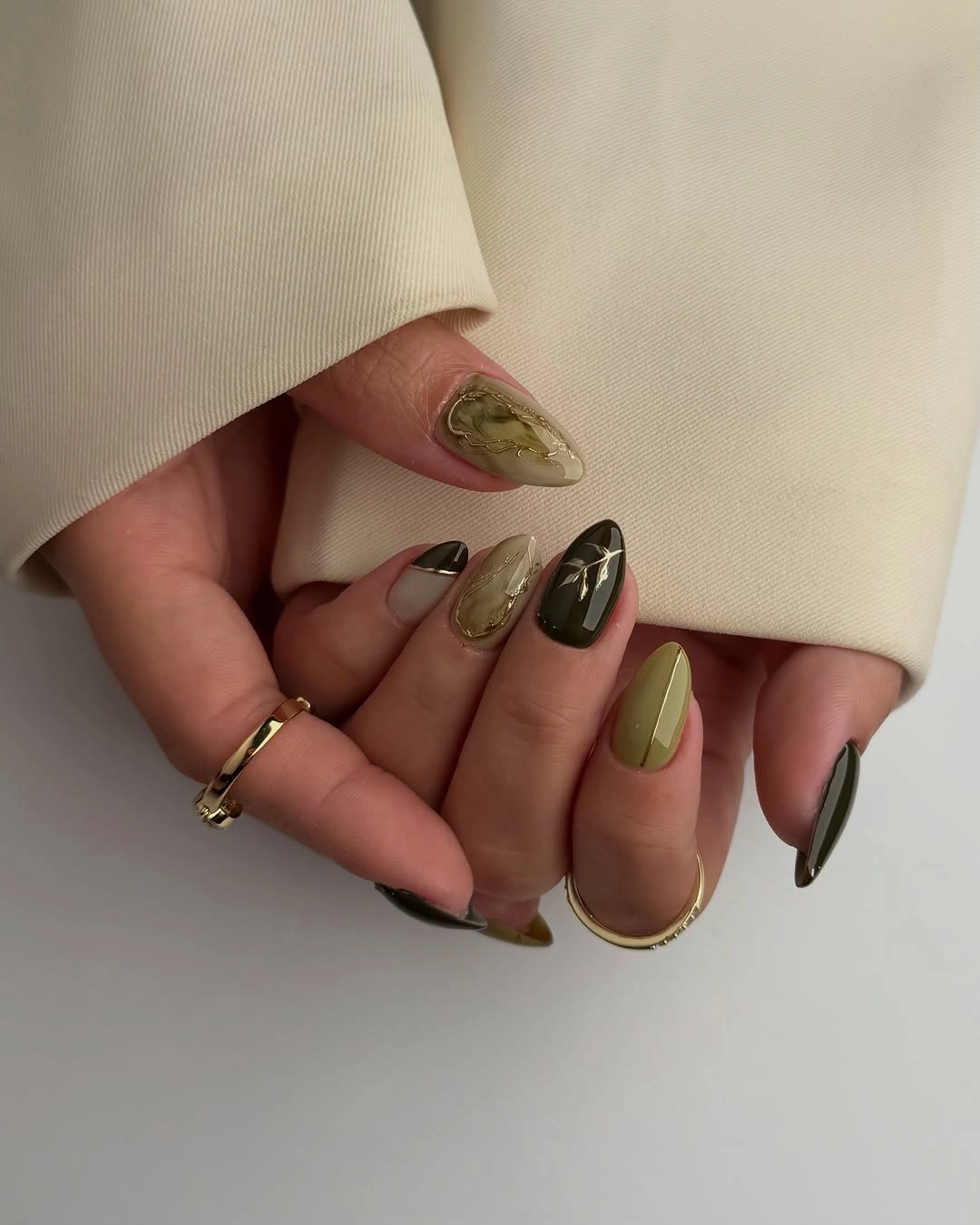 Olive chocolate and nude almond nails with swirled graphics