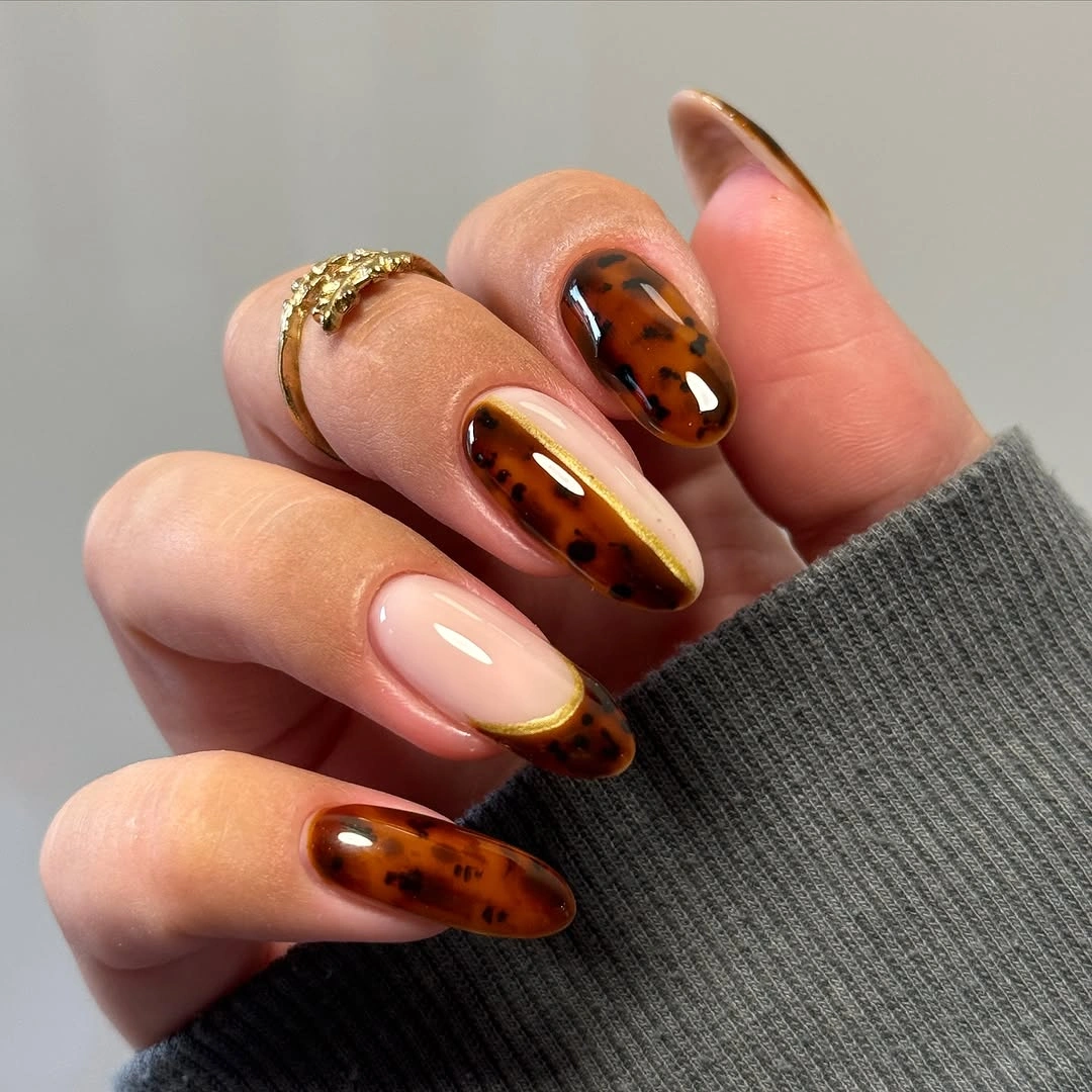 Blush almond nails with amber brown patterned accents