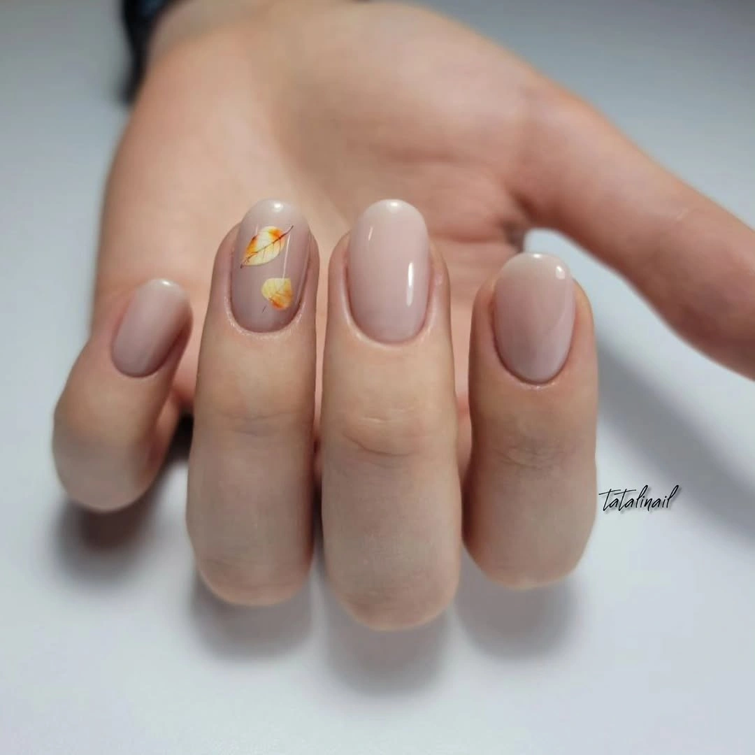 Short greige nails with tiny gold toned dot accents