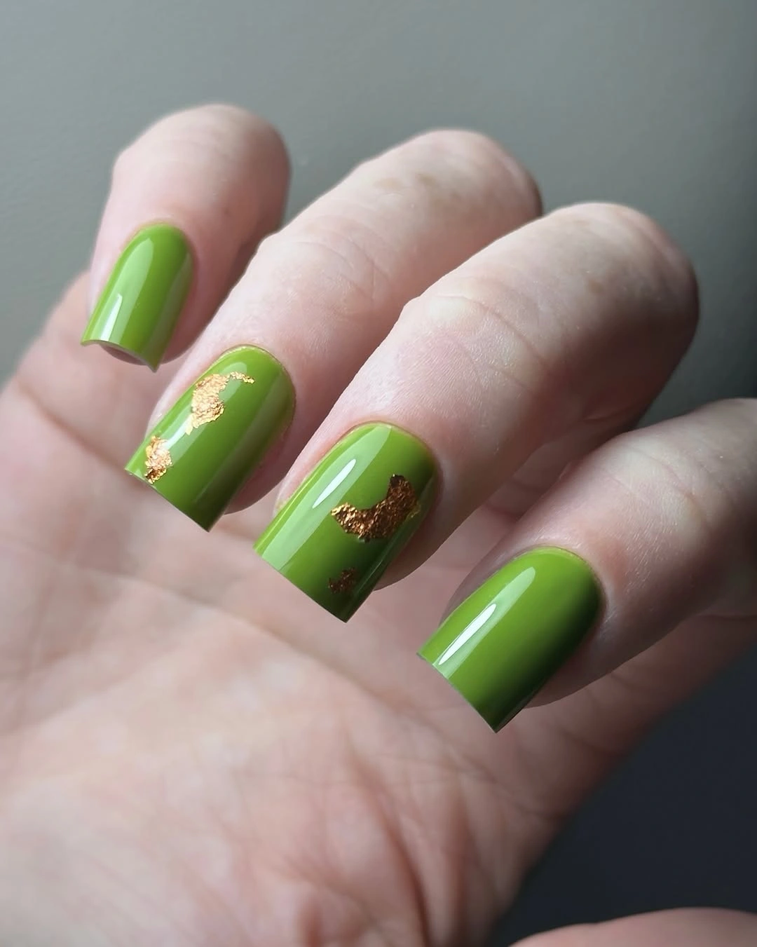 Long bright green square nails with fine metallic flecks