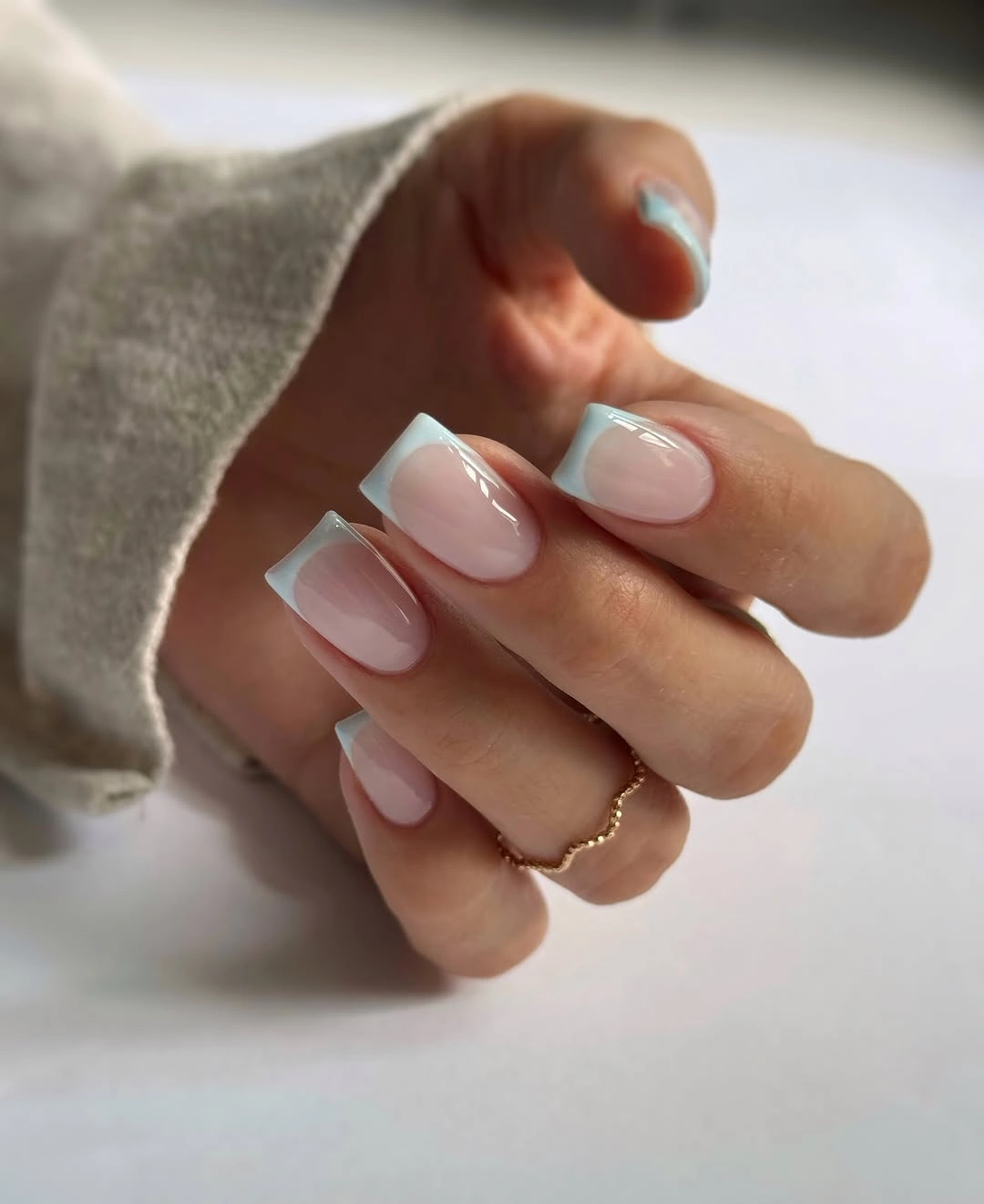 Pale blush nude nails with clean white curved tips