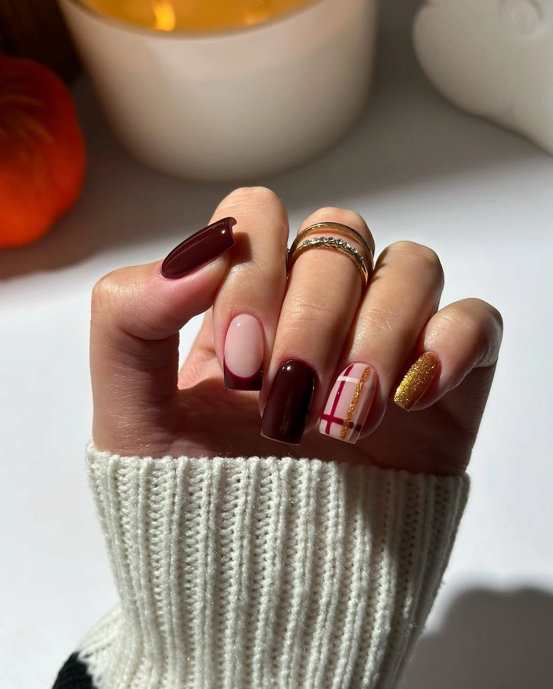 Short deep burgundy nails with warm yellow line accents