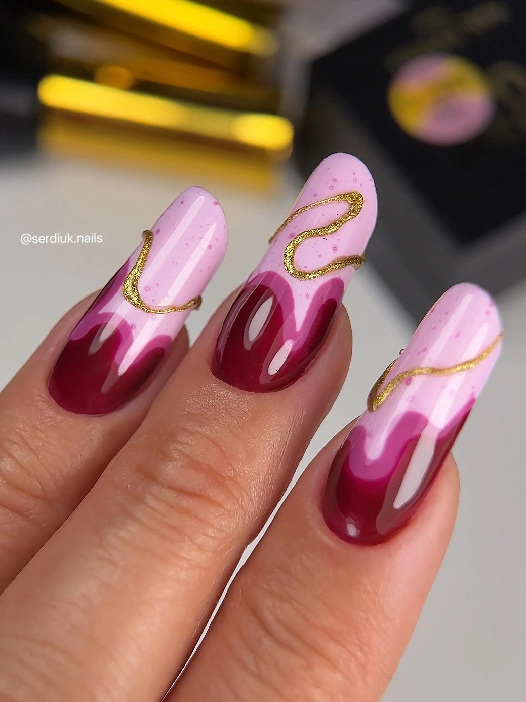 Long lavender burgundy nails with thin gold flowing lines