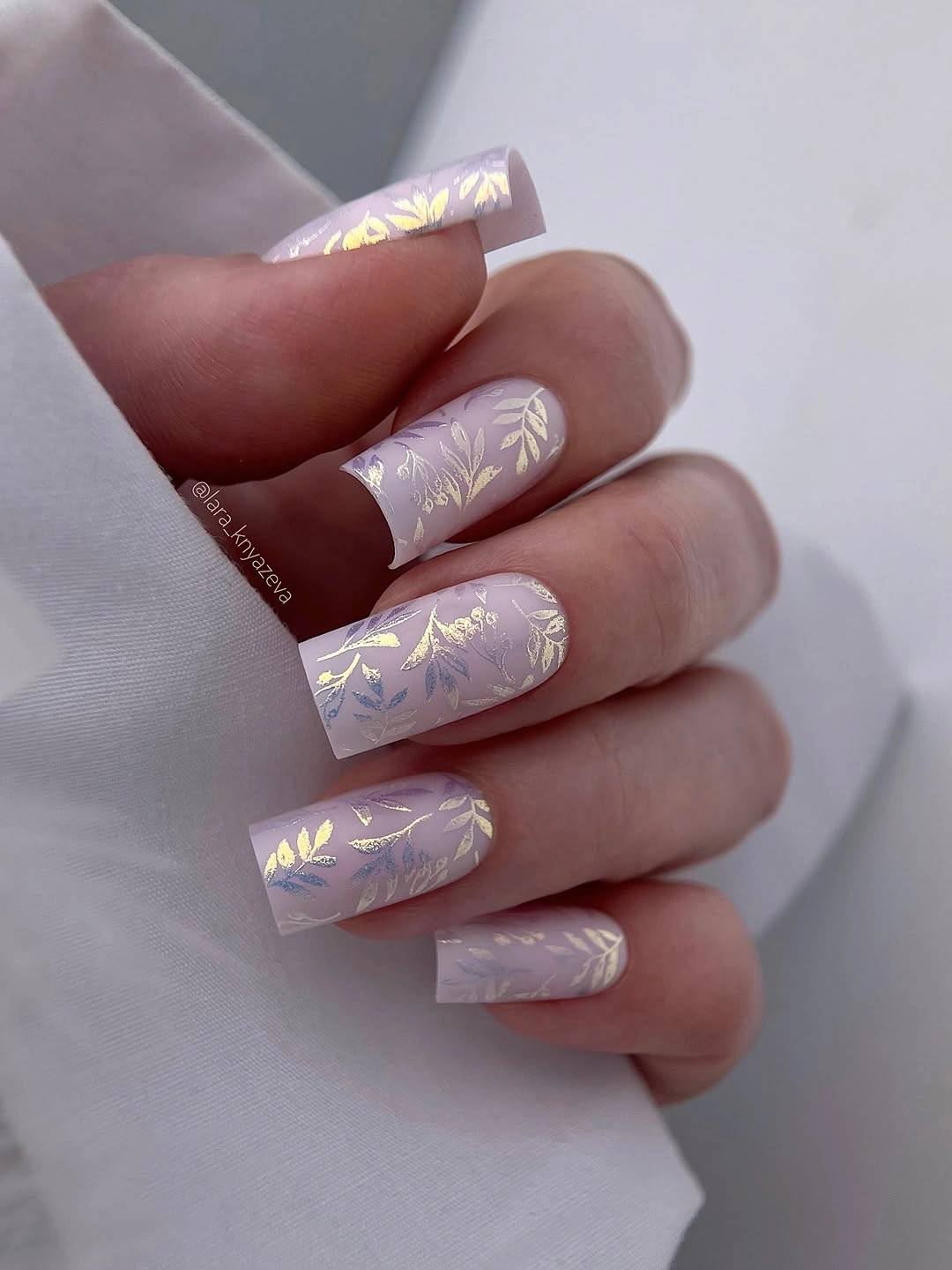 Long lavender square nails with delicate gold leaf motifs