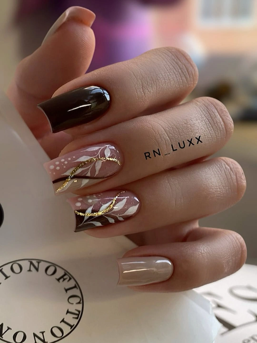 Long square nude and chocolate nails with gold leaf lines