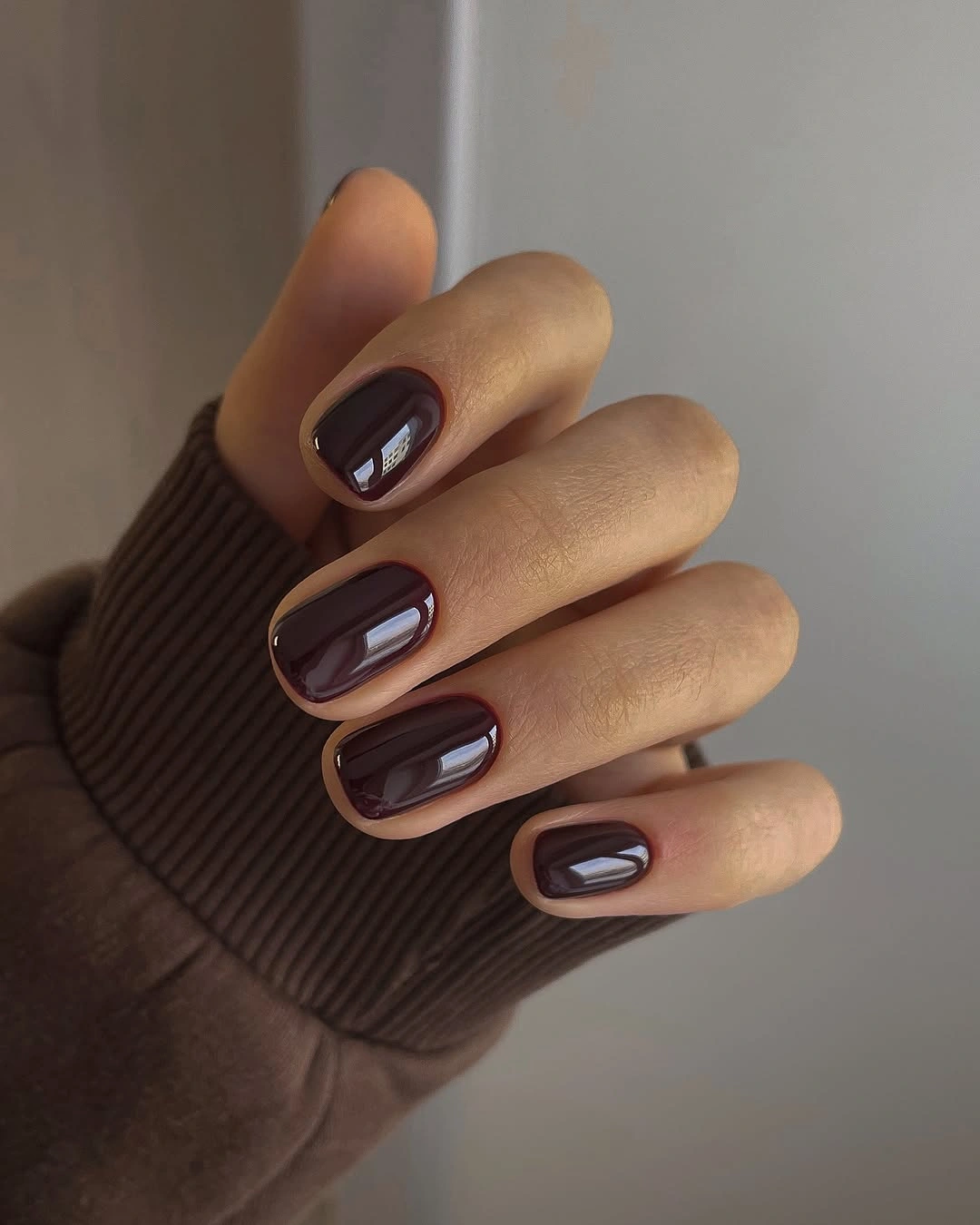 Short glossy chocolate nails with subtle reflective blocks